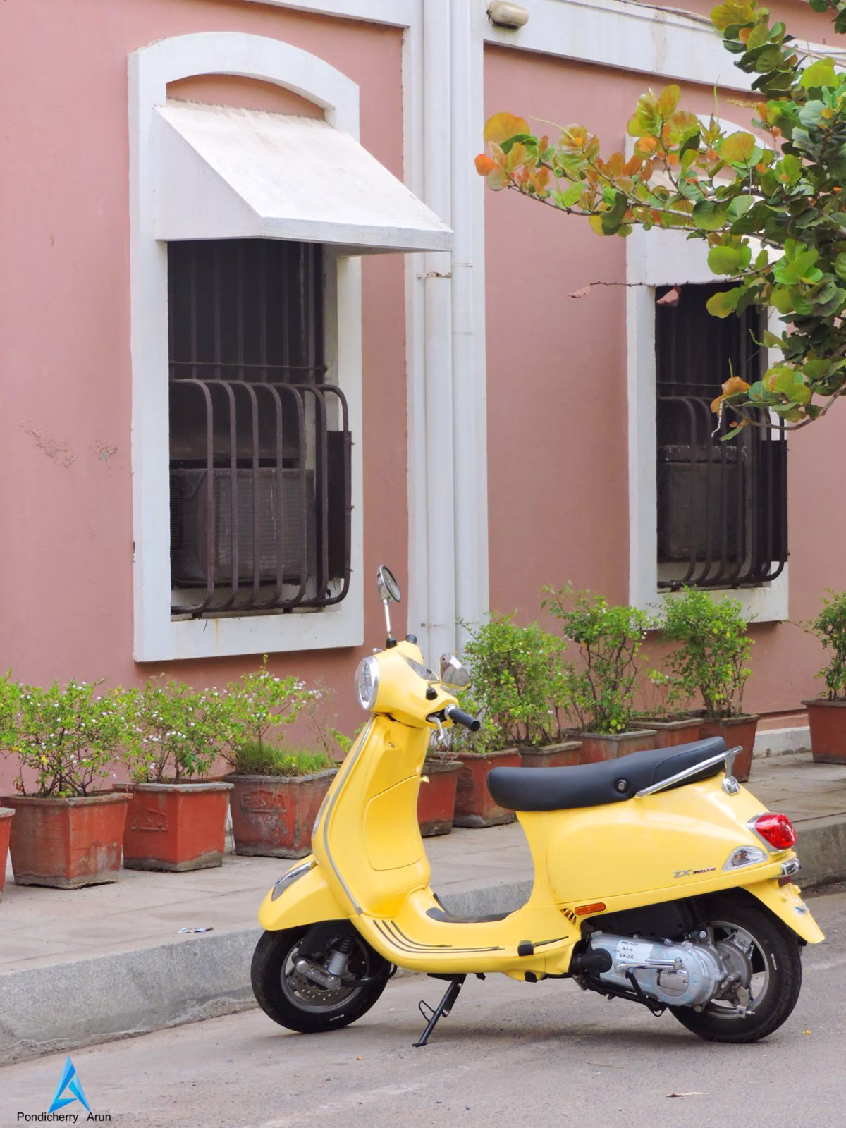Yellow Vespa parked in front of colonial building in White Town Pondicherry