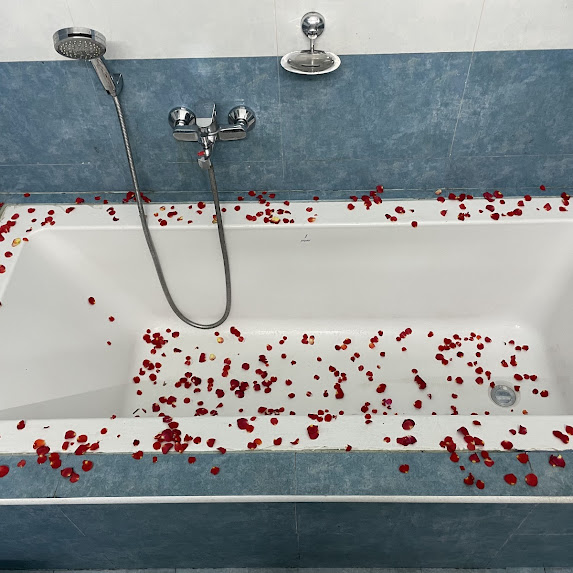 Romantic rose-petal bathtub setup for anniversary at Nivaa Stays