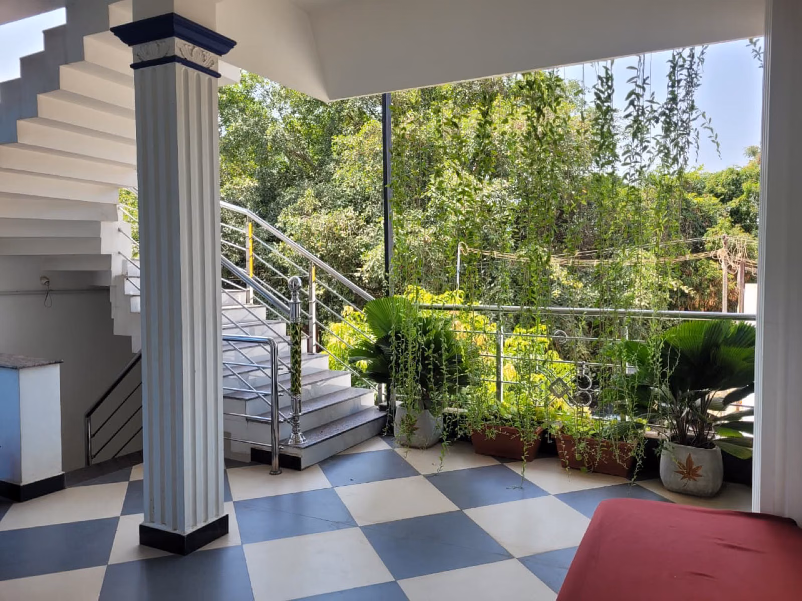 Stairwell with checkered floor and balcony greenery